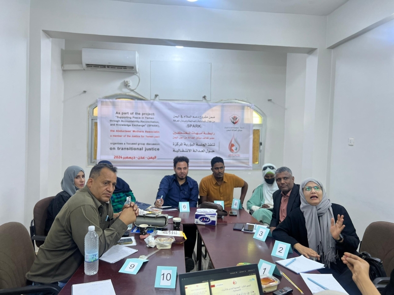 Participants sit around a table during a focused group discussion on transitional justice based on accountability, reconciliation, and knowledge exchange.